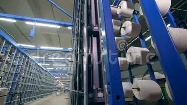 在一家纺织厂，用白色的线在架子上成排地切割。 纺织工业概念。